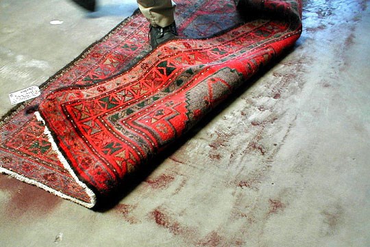 Dust being removed from the back of an Oriental rug