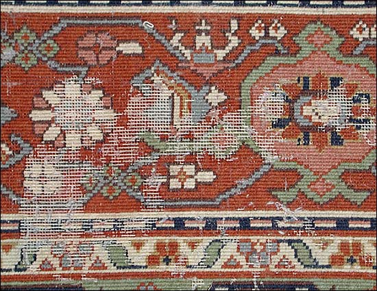 Moth damage eaten into the pile of an Oriental rug