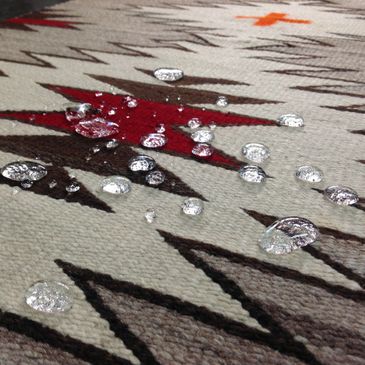 Droplets of liquid beading on a rug treated with fiber protector